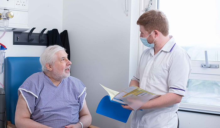 patient talking to pharmacist with a folder in hand