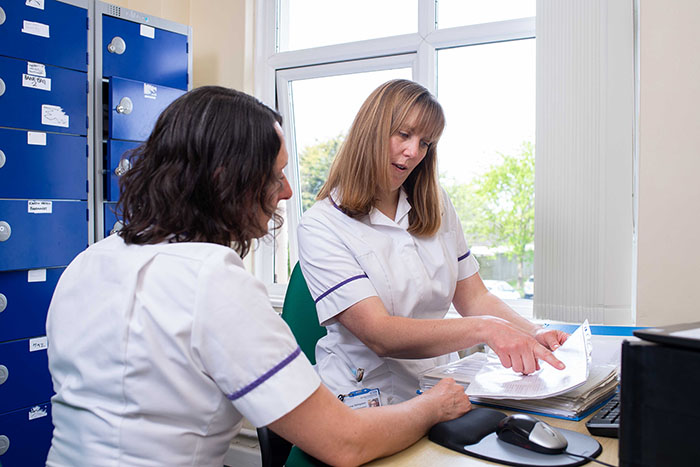 two pharmacists discussing whilst looking at a document